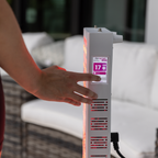 Hand clicking a screen of a red light teraphy device with a blurred background
