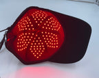 Red LED light pad on a black cap against a white background